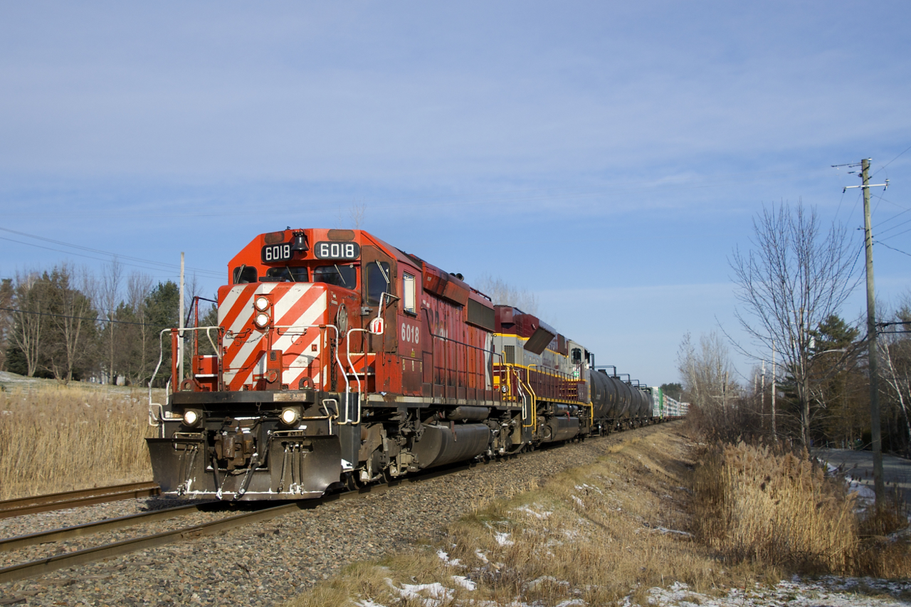 Multimarked and maroon and grey power are back in the Eastern Townships on the Sherbrooke Sub as CP 251 with CP 6018, CP 7011 and 63 cars passes the siding at Shanks.