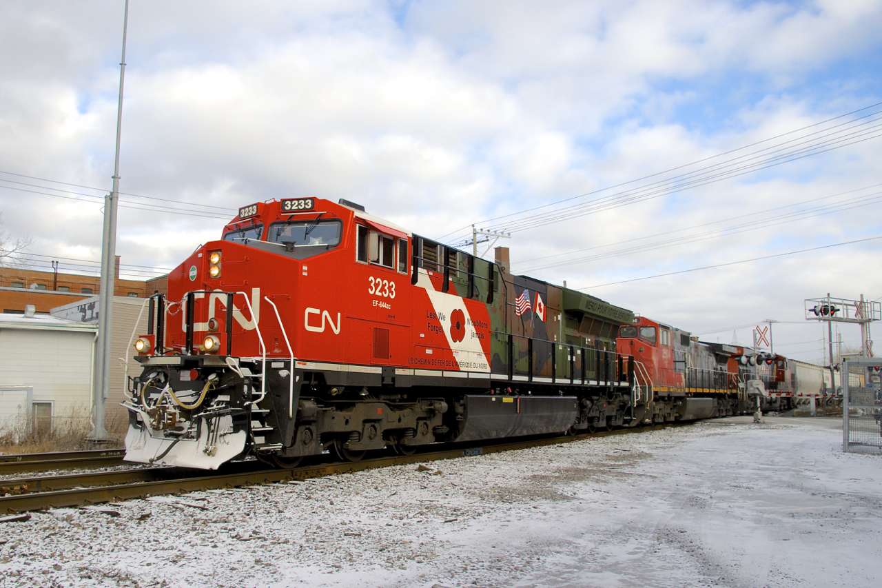 After entering the Montreal area before sunrise as the DPU on CN 322, military tribute unit CN 3233 is seen leading a short CN 527 through St-Henri, with CN 2504 & CN 2294 trailing.