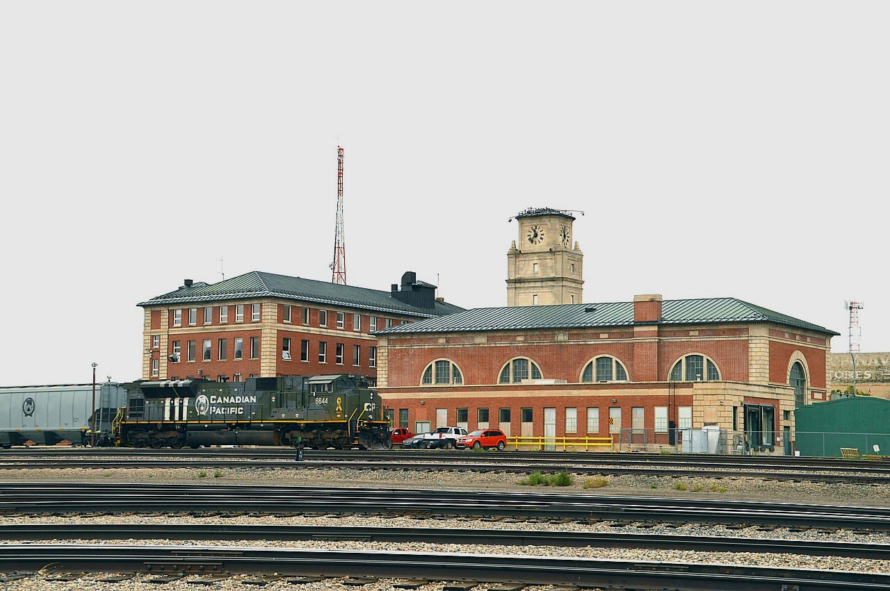 Moose Jaw's former Union Station is one impressive structure. Massive, to reflect the glory days of the CPR. It was probably the most prominent building in the city when it was constructed in 1920-1922. The tower, with its four-faced Standard Electric Time Clock, keeps good time, having been fully overhauled in 2003. The station is no longer used by the CP, having seen its last passenger train back in the 1970s. As well, back in the day this was also a CP-SOO transfer location, before SOO became part of the CP empire.  Currently inside the building is probably the fanciest liquor outlet I have ever seen, and I've seen a few. The interior has been preserved just like original, plus endless supplies of booze to check out. Just about any you could imagine.  Minimum visit: 1 Hour. :o)
In 1999 the this majestic structure was formally recognized as a Heritage Railway Station.

Oh, and out front, after servicing and ready to depart the yard eastbound is probably the most significant of the special tribute Heritage units put out by CP, the 6644 (rebuilt from 9160) which of course commemorates that famous Normandy Invasion of June 6, 1944. Running solo this trip, it appears to be the most traveled of the five military heritage units released.