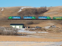 Mobile Grain's Last Mountain Railway makes it's way up the notable grade and out of the valley at Lumsden with three clean SD40s for power. On a  side note, if I had a shop like the one in the foreground, I don't link I'd ever need to go in the house again! 