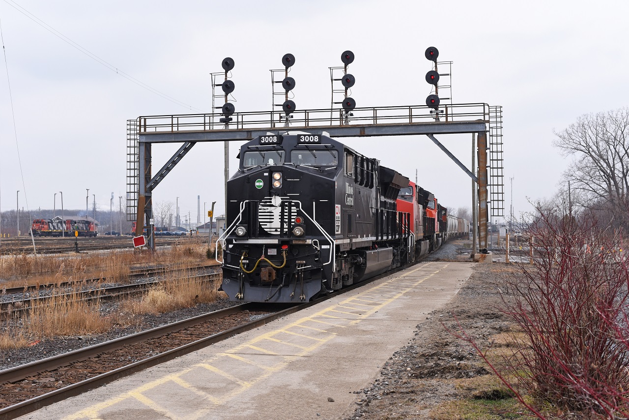 CN M394 climbs the grade out of the St. Clair River Tunnel passing under the Westbound signals at CN Hobson with none other than the IC heritage unit leading