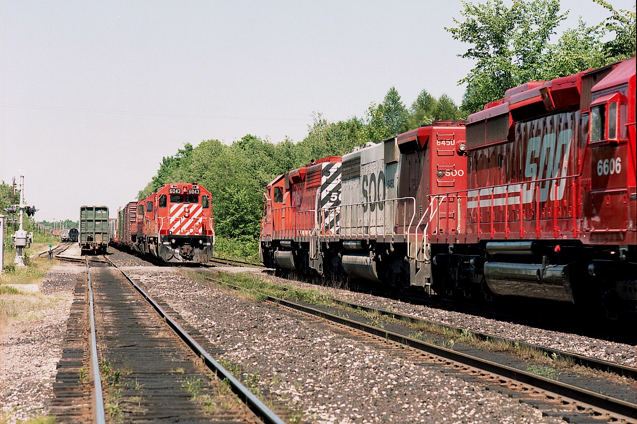 How it used to be, dept: 
I'm at First Line Nassagaweya west of Guelph Jct. This is back in the days before "No Parking" signs and other hindrances and we could just sit back and enjoy the action. This view shows CP 6043, 5533 and 4734 about to head west once the eastbound CP 5645, SOO 6450 and 6606 clears. The lads share a greeting.
Note the SOO 6450 is a "B" unit; the only one on the roster. It was retired in Oct of 1993. The 6606 was retired in 2012 and converted to one of those ECO units, number 5019. Of the CPs, only 6043 remains on their roster.