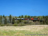 In response to <a href=http://www.railpictures.ca/?attachment_id=43796>Arnold's image of Souris</a> I present this quaint scene. Seen trundling through the countryside of PEI, CN RSC-14 1757 leads van 79892 eastbound crossing the Brudenell River just a few miles from it's destination of Montague with cylindrical hoppers in tow.  The <a href=http://www.cwrailway.ca/cnrha.ca/Timetables/Atlantic%20Region/Moncton%20sub/Montague.jpg>1980 timetable</a> lists no scheduled trains over the line so I am marking this as Extra 1757.  About two and a half years remain for rails on the island, as the last train will depart by ferry on December 28, 1989, led by RSC-14s 1750, 1786.  Most of the line has since become part of the Confederation Trail.<br><br>CN 1757, built by MLW as RS18 3852 in 1960, would be rebuilt and renumbered in 1975 to 1757 as an RSC-14 with A-1-A trucks and the horsepower reduced from 1800 to 1400.  It was sold off to the Cape Breton & Central Nova Scotia Railway in 1994 as their 3852, named J. S. D. Thompson (John Sparrow David Thompson; 4th Prime Minister of Canada; 1892 - 1894), and was retrucked with standard B-B trucks from RS18 CN 3615.  3852 would be scrapped in 1998.<br><br><i>G. W. Cross Photo, Jacob Patterson collection slide.</i>