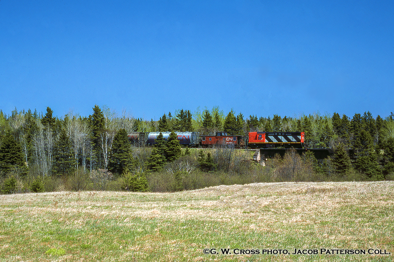 In response to Arnold's image of Souris I present this quaint scene. Seen trundling through the countryside of PEI, CN RSC-14 1757 leads van 79892 eastbound crossing the Brudenell River just a few miles from it's destination of Montague with cylindrical hoppers in tow.  The 1980 timetable lists no scheduled trains over the line so I am marking this as Extra 1757.  About two and a half years remain for rails on the island, as the last train will depart by ferry on December 28, 1989, led by RSC-14s 1750, 1786.  Most of the line has since become part of the Confederation Trail.CN 1757, built by MLW as RS18 3852 in 1960, would be rebuilt and renumbered in 1975 to 1757 as an RSC-14 with A-1-A trucks and the horsepower reduced from 1800 to 1400.  It was sold off to the Cape Breton & Central Nova Scotia Railway in 1994 as their 3852, named J. S. D. Thompson (John Sparrow David Thompson; 4th Prime Minister of Canada; 1892 - 1894), and was retrucked with standard B-B trucks from RS18 CN 3615.  3852 would be scrapped in 1998.G. W. Cross Photo, Jacob Patterson collection slide.