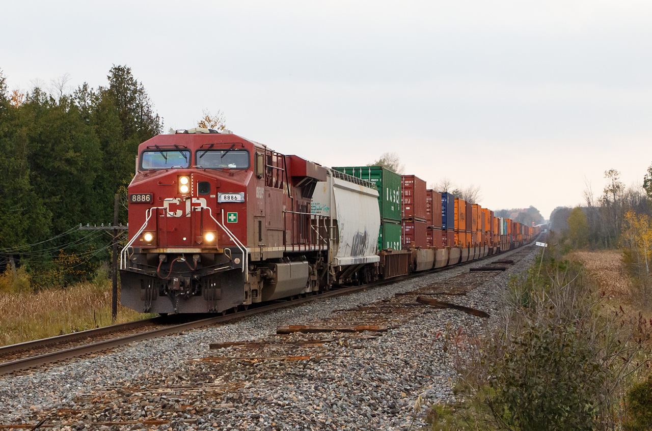 CP #142 is underway after making a setout and pickup at the east yard in Smiths Falls. The train has over 13,000 tons with only 8842 as a DPU to help 8886. While they were permitted to run at 60 mph, the crew told the RTC "not to expect any miracles". In response, the RTC arranged for #143 to take the siding in Winchester so #142 could hold the main.

Clearly, Red Green has hired on with CP, and was assigned to fix the numberboard for 8886.