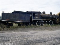 Normetal Mining 219, a former Temiskaming & Northern Ontario Railway 4-6-0 steam locomotive, is seen stored in the Ontario Northland Railway's yard in Cochrane ON in October 2000. At the time of this photo it had been stored in Cochrane for nearly two and a half decades and was is looking more than a little worse for wear, haphazardly stored out of the way at the end of a yard track with the rear tender truck shoved up against a pile of ties and dirt mount.<br><br>T&NO 219 was built by MLW in 1907 as one of six 4-6-0 units, originally numbered 119 and later renumbered 219. TN&O sold the steamer to Normetal Mining in Quebec in 1938 who used it for industrial switching. It was sold to a private owner in 1976 who had dreams of running excursions with it on the Spruce Falls Power & Paper Company line. It was moved to Ontario Northland in Cochrane for work, but the owner passed away and plans fell through, so eventually ONR (successor of the T&NO) came into ownership of the old engine. 219 was stored for nearly three and a half decades in by ONR in Cochrane until 2012, when it was sold off and acquired by the Northern Ontario Railroad Museum & Heritage Centre (NORMHC), who moved it to their museum in Capreol in 2014.