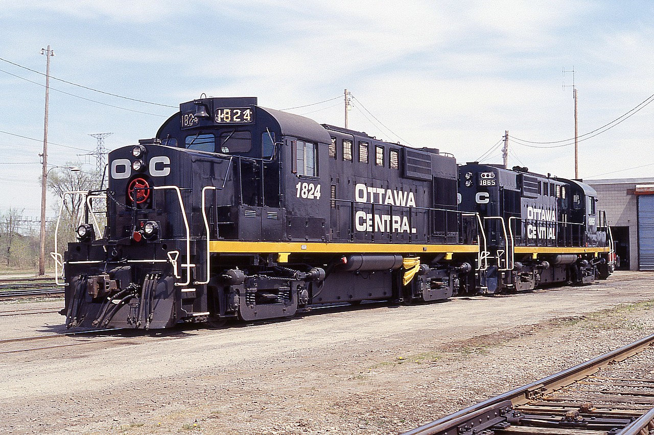 I never much cared for locomotives in solid black paint. (Norfolk Southern comes to mind) However, OCRR 1824 and 1865 look splendid.  No wonder; they are freshly painted.  The fledgling Ottawa Central is less than 6 months old when this photo was taken, and started with a fleet of RS18u diesels cast from the Canadian Pacific. From red to black, same numbers.
It seemed we hardly got to know the Ottawa Central before it was reabsorbed back into the CN after a short lived independence, so to speak, from 1998 to 2008. It had been a wholly owned subsidiary of the Quebec Railway Corporation.