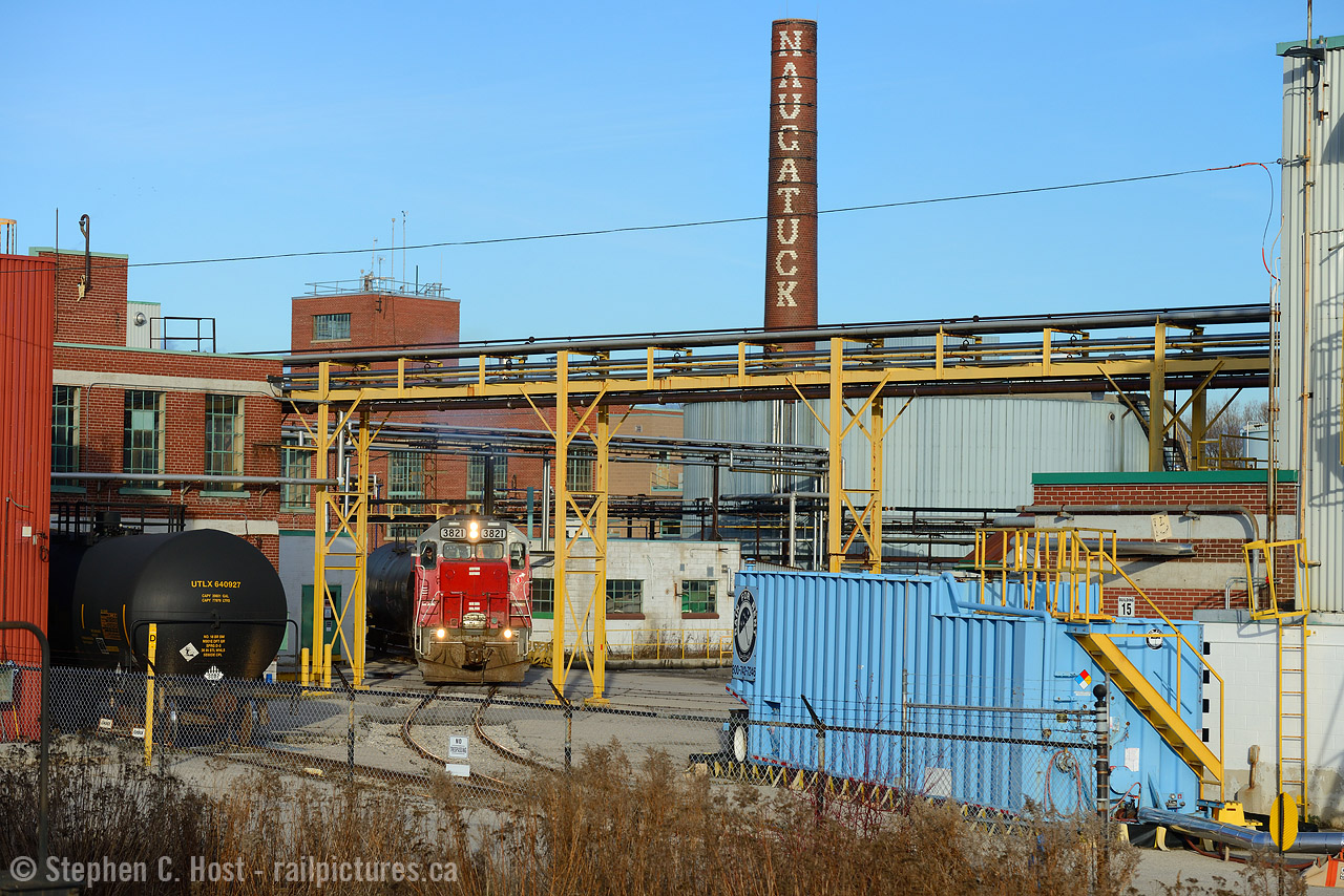 Not a creature was stirring, not even a mouse.. as they say for Christmas Eve - this was no different. I ended up following this train to and from Elmira on Christmas Eve, after chasing 580 to Kitchener I found 584 working and they quickly went north, running early to get the crew home in time for Christmas. No creature was stirring - everyone was already sent home  - not in any business, not at Chemtura, nothing. Zero. It was just me and the two crew of the railway. I took this photo from behind a business, and the name built into the smokestack is what intrigued me. "naugatuck" was the name of this factory as it was in 1941. GEXR with 3821 is reversing into the facility to perform work, which takes time in the tight confines of this plant. This place hasn't changed all that much in the last 80 years it would seem.

Note: 3821 is now GEXR 2073.
