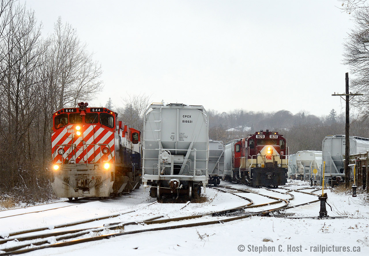 A New Years Eve meet on the Ontario Southland Railway. Hogger Jon Snook on Job 2 is exchanging new years pleasantries over the radio to Job 1, while they work out instructions for Job 1's setoff for lower yard from CN. Job 2 will have the pleasure of switching the CN cars into PDI Elizabeth St and PDI liquids, while Job 1 heads back to the jct to drill the CPR interchange. Note the extra class lights on both trains. Happy New Years folks!.