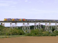 The eastbound "Canadian" has just departed the former CN crew change point at Rivers and crosses the Little Saskatchewan River, AKA Minnedosa River. The third unit is in Kool-Aid wrap, several units were wrapped in advertising at the time, a revenue source.