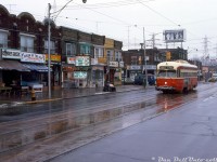 TTC PCC 4538 (A8-class built new for the TTC in 1951 by CC&F) trundles westbound on St. Clair Avenue West past Silverthorn Avenue in the light snow, passing a line of small mom and pop stores common to most local neighbourhoods (selling paints, groceries, seafood, fashion, meats, tailor service, and prescription drugs). This view is looking east, with part of the CNR Newmarket Sub underpass visible in the distance near the coal dealer silos (about where Robert McMann shot an eastbound streetcar from <a href=http://www.railpictures.ca/?attachment_id=43648><b>here</b></a>).
<br><br>As the "newest" PCC cars in the fleet, the 1951-built 4500-4549 A8-class of streetcars would enjoy the most longevity out of any TTC PCC, outliving the secondhand cars, the early air-electrics (A1-A5 classes 4000-4299) and most of the older A6-A7 cars (4300-4499). A handful were even rebuilt for the Harbourfront LRT line of the early 90's, but all disposed of (except for two) after operating for a number of years on that line.
<br><br>
<i>J. Bryce Lee photo, Dan Dell'Unto collection slide.</i>