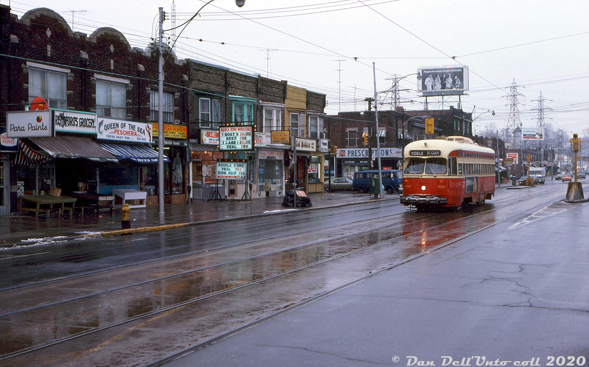 TTC PCC 4538 (A8-class built new for the TTC in 1951 by CC&F) trundles westbound on St. Clair Avenue West past Silverthorn Avenue in the light snow, passing a line of small mom and pop stores common to most local neighbourhoods (selling paints, groceries, seafood, fashion, meats, tailor service, and prescription drugs). This view is looking east, with part of the CNR Newmarket Sub underpass visible in the distance near the coal dealer silos (about where Robert McMann shot an eastbound streetcar from here).
As the "newest" PCC cars in the fleet, the 1951-built 4500-4549 A8-class of streetcars would enjoy the most longevity out of any TTC PCC, outliving the secondhand cars, the early air-electrics (A1-A5 classes 4000-4299) and most of the older A6-A7 cars (4300-4499). A handful were even rebuilt for the Harbourfront LRT line of the early 90's, but all disposed of (except for two) after operating for a number of years on that line.

J. Bryce Lee photo, Dan Dell'Unto collection slide.