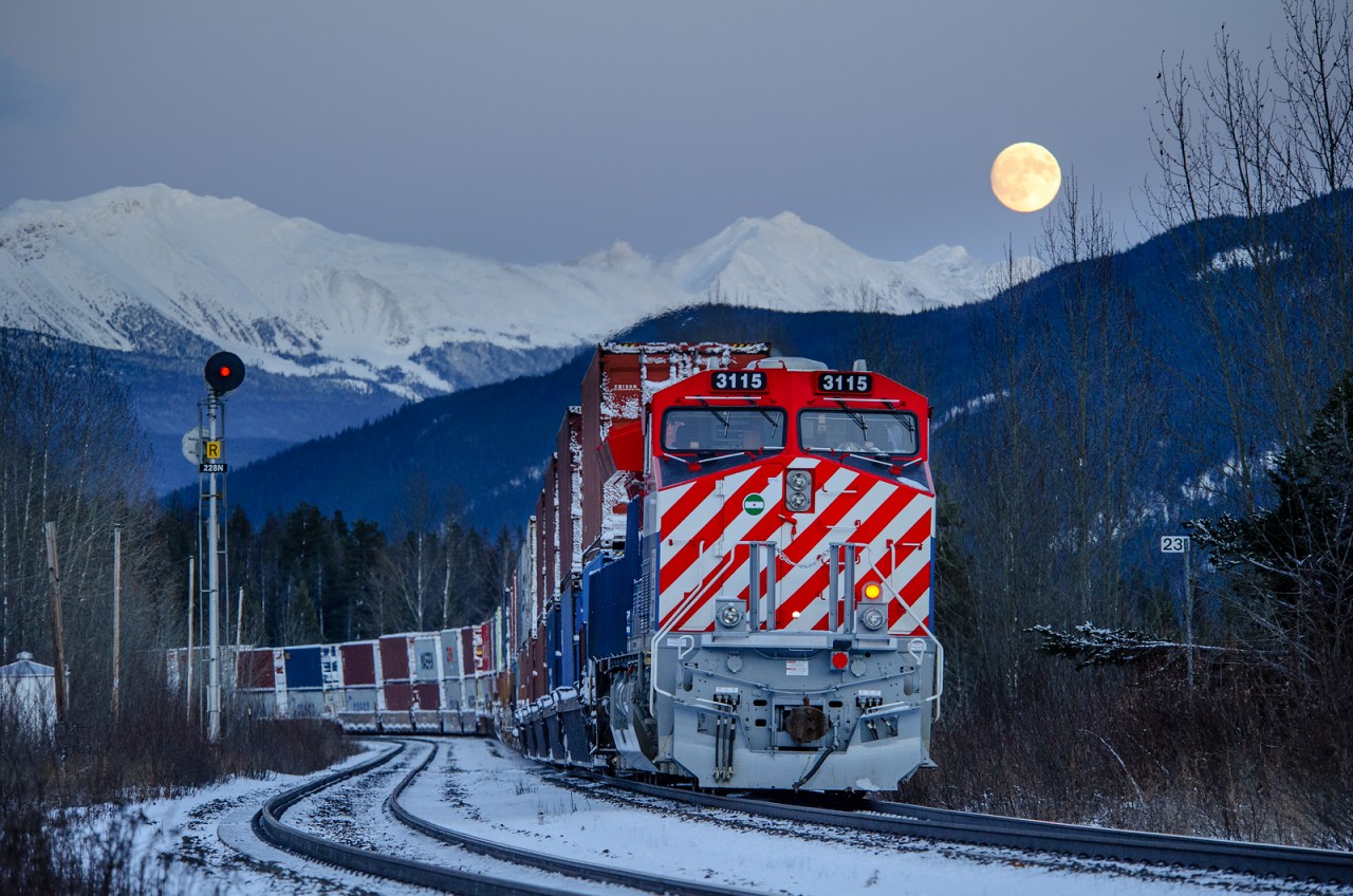 A full moon rises over Lucerne, BC as Q198's train slowly makes its way towards a congested Jasper, AB with CN ET44AC 3115 bringing up the rear.