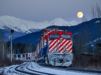 A full moon rises over Lucerne, BC as Q198's train slowly makes its way towards a congested Jasper, AB with CN ET44AC 3115 bringing up the rear.