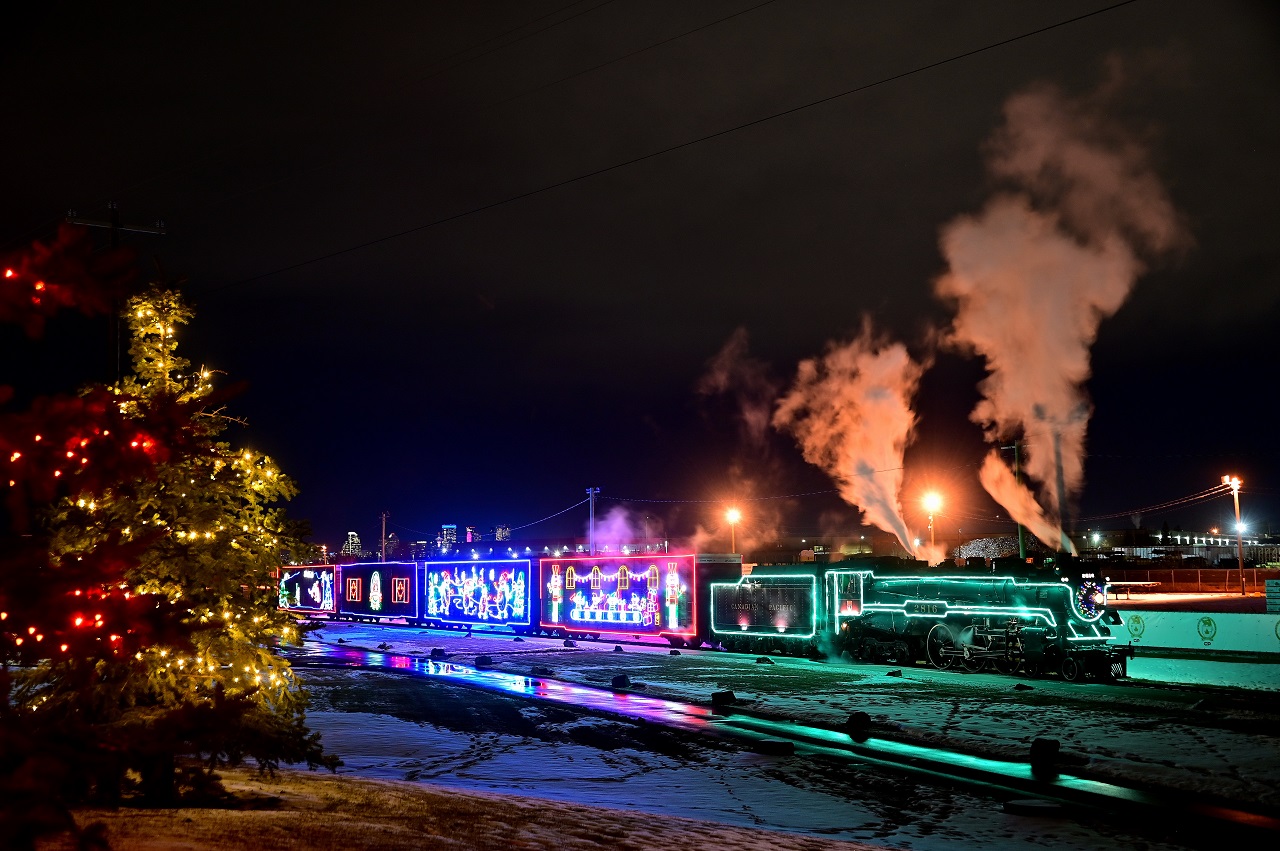 Decorated with festive Christmas lights, 2816 shines within CP's brightly-lit Ogden campus in Calgary during filming of the "Holiday Train at Home".  The tower's of Calgary's downtown core gleam in the background as the 90 year-old Hudson simmers quietly waiting for her turn in front of the camera.