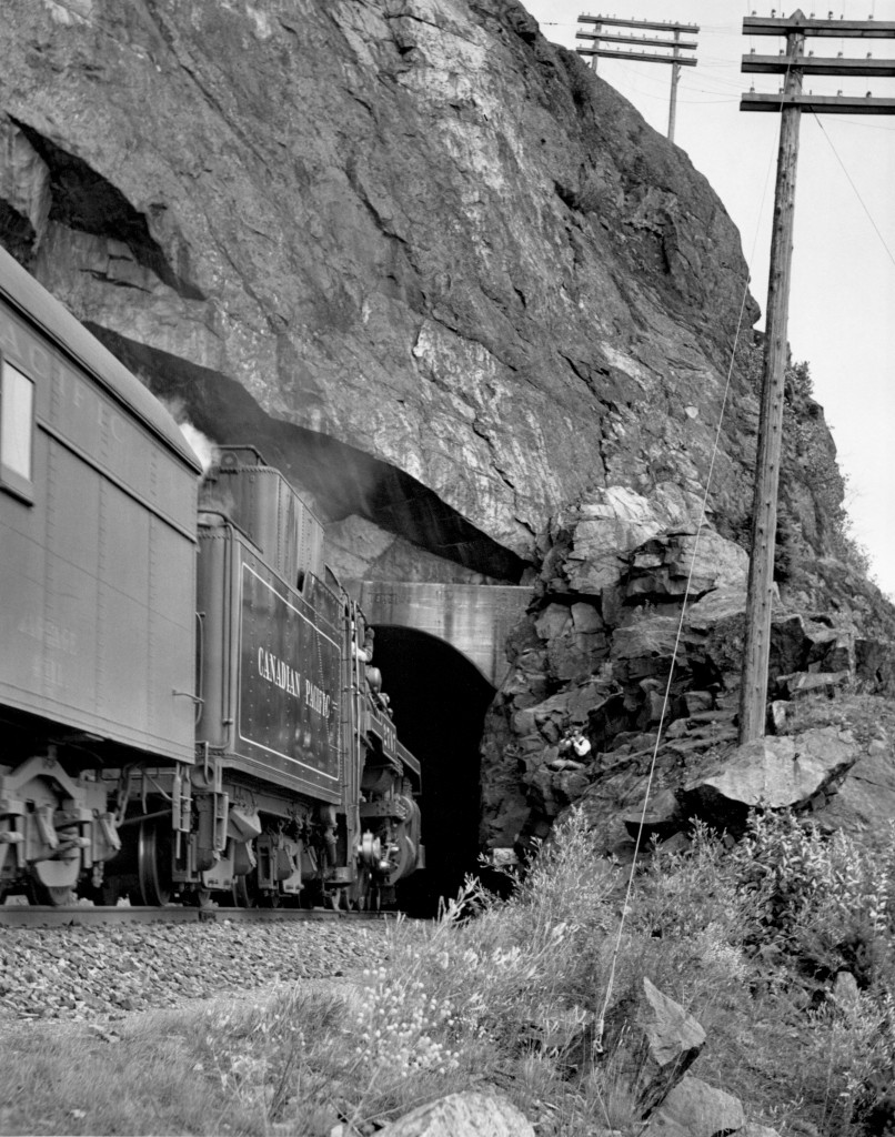 Second section of train no. 2 with engine 2707 at Harrison tunnels.  Engineer is waving at my uncle you can see crouched on the rocks near the tunnel.

In 1946 to 1949, my uncle Joe and my father Andy went railfanning together.  They called it "chasing trains".  My dad took the still pictures you see here and my uncle took movies with the family Bell and Howell 16mm movie camera.  It is a wind up camera and takes 16 frames/second.  You can find the videos by googling "youtube smokeywoodstover joe morin".  My uncle did not film any engines sitting around the shops, he only did action shots of trains passing and from the moving trains.