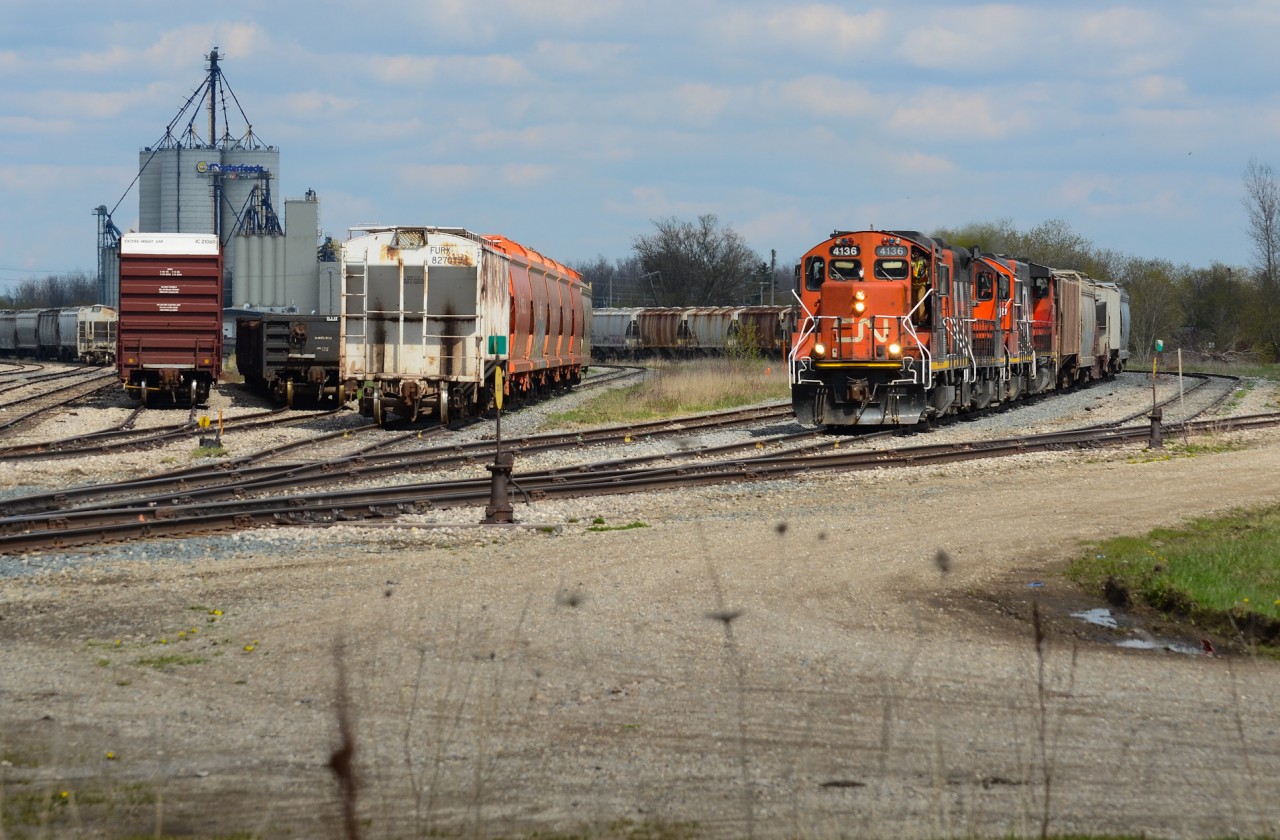 Arriving in Stratford Yard with a decent amount of tonnage is 568 led by a favourable no GMTX 4 pack of geeps 3 being GP9Rm’s as the conductor exits the unit to prepare for the set out. The units are relaxing now after an aggressive trip from Kitchener in the high notches trying to bring the train up to track speed and make good time. I believe the slow order (10mph I think) over hwy 7/8 in New Hamburg was still in place as well. The track that cuts out to the right I believe was part of the Drumbo Sub lead which went down to Paris, a line that was relatively straight down to the south east.