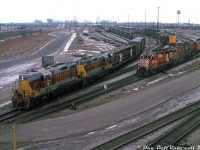 For a period in 1978-1979,  CP had Algoma Central GP7's 150 and 154 on lease (both part of ACR's first GP7 order built in 1951). They mostly ran out of Toronto on various road and <a href=http://www.railpictures.ca/?attachment_id=41521><b>local jobs</b></a>. Here, the pair head up CP's Couboug Turn, getting ready to leave Toronto (Agincourt) Yard at the north-east end by Finch Avenue, in order to head down the connector and join the Belleville Sub at Staines. No shortage of open trilevel and bilevel autoracks are in today's train, likely bound for the GM plant in Oshawa.<br><br>Power on the adjacent track (possibly heading to/from the diesel shop in the distance) includes CP GP35 5016, M630 4510, another big M and an A-B pair of F-units. Two Alco/MLW switchers wait behind, likely pulldown power that worked the east end of the yard doing flat-switching. The old van shop is visible in the background.<br><br><i>Keith Hansen photo, Dan Dell'Unto collection slide.</i>