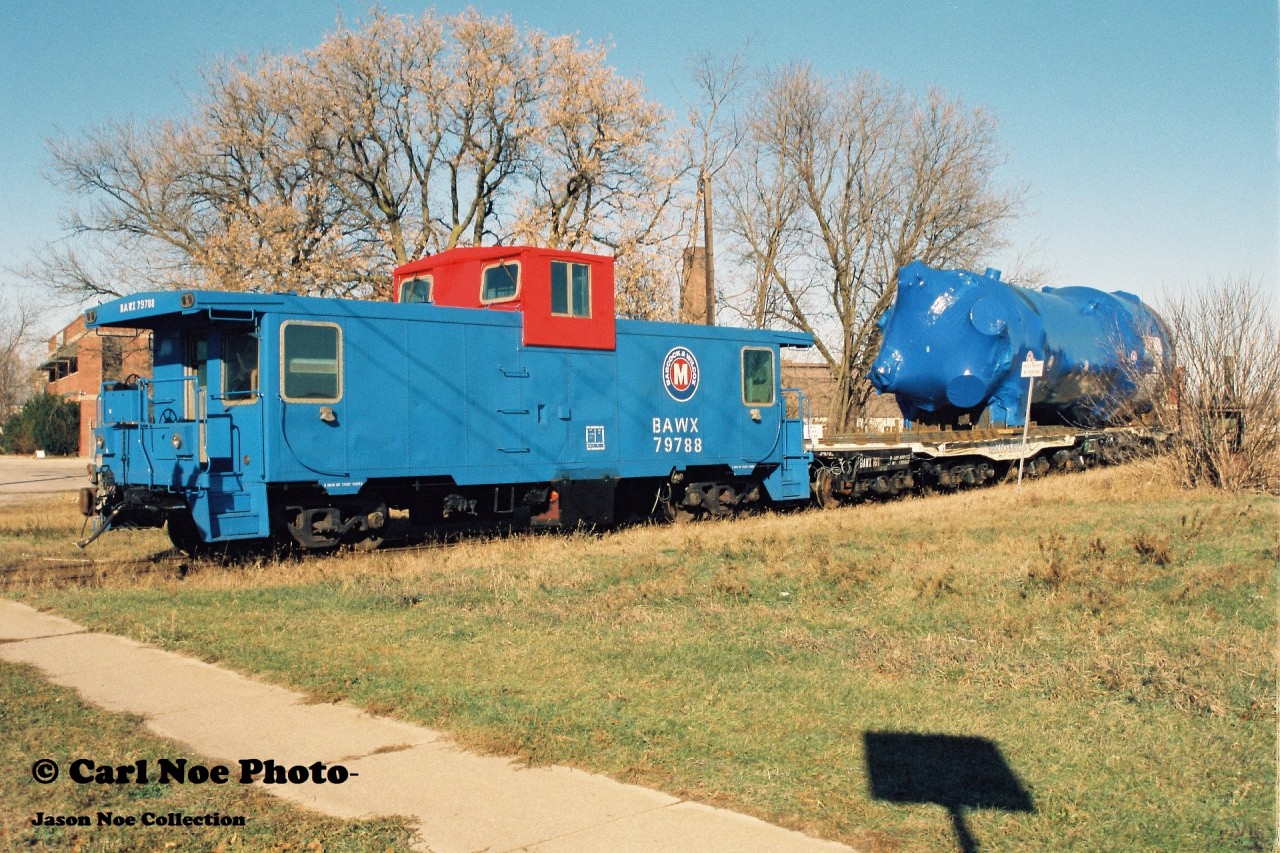 BAWX caboose 79788, which is former CN 79788, is viewed being shoved around the west leg of the wye in Galt along with a freshly constructed dimensional load by a CP GP9u. The caboose and large load originated from the nearby Babcock & Wilcox facility on the Waterloo Subdvision. Twenty-six years later and this plant is still manufacturing large components and is currently regularly serviced by CP.