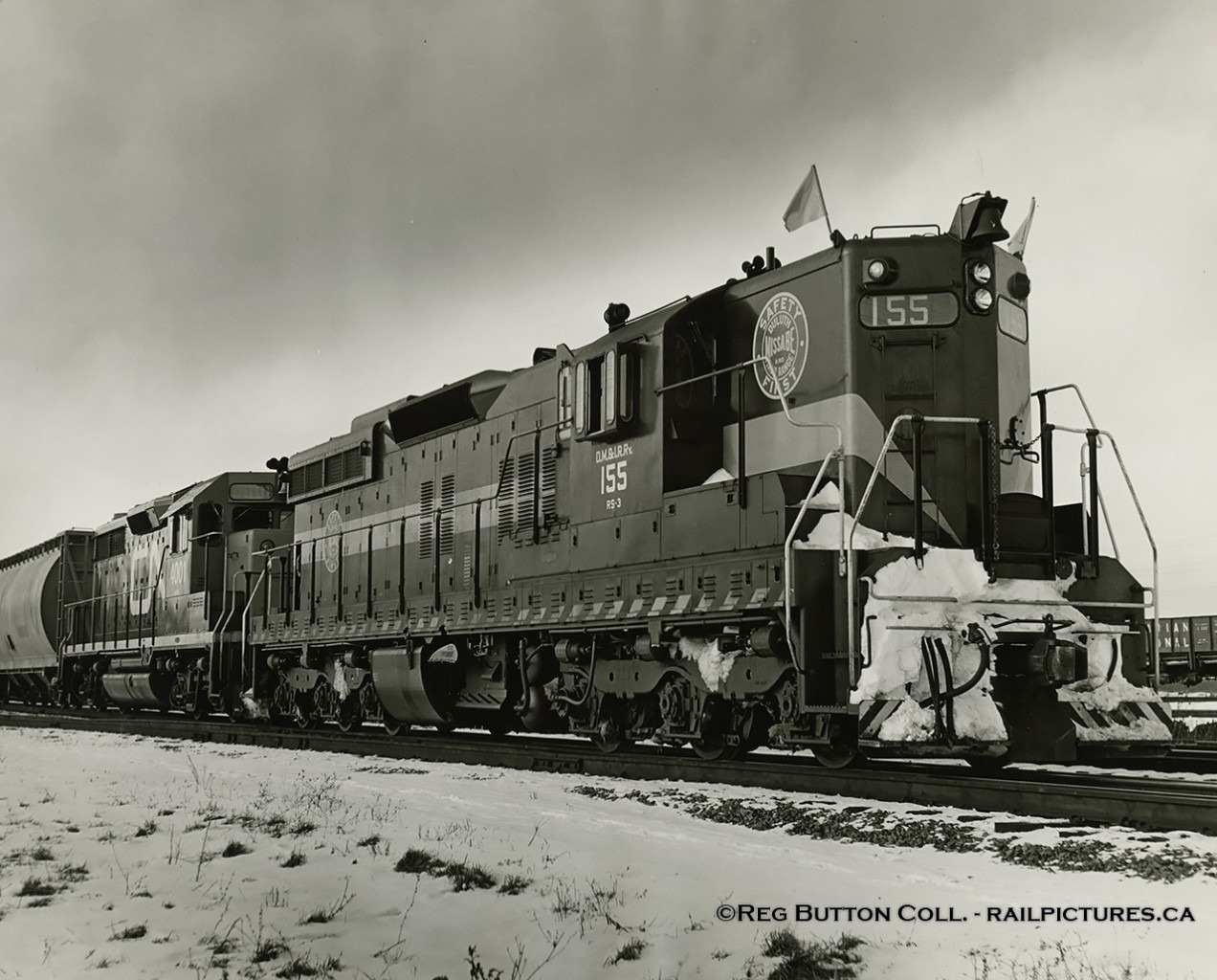 Extra flags flying high, DM&IR SD9 155 leads CN GP35 4001 eastbound through Merriton on Saturday, January 15, 1966.  From the winter of 1963/64 through winter 1973/74 DM&IR SD9 and SD18 units were often leased by CN, CP and a few other lines.  The winter of 1965/66 saw CN leasing 20 units, 155 being one of them (the only time it was leased), and the CP leasing 16.DMIR 155 was one of 73 SD9s built by EMD and delivered in March, 1958.  The unit would later be sold to Independent Locomotive Service in 1993 and rebuilt/renumbered as ILSX 1374.  It's last known operation was the Dakota Quality Grain Cooperative in Ross, North Dakota about 2009.  Trailing unit, CN 4001, was the second of two GP35s built for CN (the other being CN 4000).  Both units would be renumbered 9300/9301 respectively in 1981, and retired from CN's roster in 1984.  9301 would be stripped of usable parts and scrapped at Mandak Metals, while 9300 would be sold to the Dakota, Missouri Valley & Western (DMVW) in 1989 as their 323, eventually being scrapped in 2002.More DMIR on CN:Roger Lalonde: Jan. 18, 1965 at Montreal.Bill Thomson: March, 1966 at Halwest.Doug Hately: Dec. 27, 1965 at Bowmanville.CN GP35s:CN 4000 by Bill Thomson: Mimico, Oct. 1964CN 4001 by Bill Thomson: Mimico, Oct. 1964CN 9300 by Doug Lawson: Dead and drained at Edmonton, Feb. 1984CN 9301 by Doug Lawson: Dead and drained at Edmonton, Feb. 1984Thanks to Bruce Mercer and Doug Wingfield for further information.