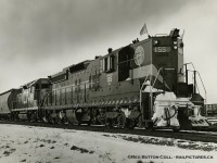 Extra flags flying high, DM&IR SD9 155 leads CN GP35 4001 eastbound through Merriton on Saturday, January 15, 1966.  From the winter of 1963/64 through winter 1973/74 DM&IR SD9 and SD18 units were often leased by CN, CP and a few other lines.  The winter of 1965/66 saw CN leasing 20 units, 155 being one of them (the only time it was leased), and the CP leasing 16.<br><br>DMIR 155 was one of 73 SD9s built by EMD and delivered in March, 1958.  The unit would later be sold to Independent Locomotive Service in 1993 and rebuilt/renumbered as <a href=https://www.railpictures.net/showimage.php?id=282978&key=5296127>ILSX 1374.</a>  It's <a href=https://farm5.staticflickr.com/4069/4286118252_fb4884a4b4_o.jpg>last known operation</a> was the Dakota Quality Grain Cooperative in Ross, North Dakota about 2009.  Trailing unit, CN 4001, was the second of two GP35s built for CN (the other being CN 4000).  Both units would be renumbered 9300/9301 respectively in 1981, and retired from CN's roster in 1984.  9301 would be stripped of usable parts and scrapped at Mandak Metals, while 9300 would be sold to the Dakota, Missouri Valley & Western (DMVW) in 1989 <a href=http://www.rrpicturearchives.net/showPicture.aspx?id=3273877>as their 323,</a> eventually being scrapped in 2002.<br><br>More DMIR on CN:<br>Roger Lalonde: <a href=http://www.railpictures.ca/?attachment_id=26619>Jan. 18, 1965 at Montreal.</a><br>Bill Thomson: <a href=http://www.railpictures.ca/?attachment_id=25143>March, 1966 at Halwest.</a><br>Doug Hately: <a href=http://www.railpictures.ca/?attachment_id=24236>Dec. 27, 1965 at Bowmanville.</a><br><br>CN GP35s:<br>CN 4000 by Bill Thomson: <a href=http://www.railpictures.ca/?attachment_id=27396>Mimico, Oct. 1964</a><br>CN 4001 by Bill Thomson: <a href=http://www.railpictures.ca/?attachment_id=26650>Mimico, Oct. 1964</a><br>CN 9300 by Doug Lawson: <a href=http://www.railpictures.ca/?attachment_id=35749>Dead and drained at Edmonton, Feb. 1984</a><br>CN 9301 by Doug Lawson: <a href=http://www.railpictures.ca/?attachment_id=35750>Dead and drained at Edmonton, Feb. 1984</a><br><br>Thanks to Bruce Mercer and Doug Wingfield for further information.