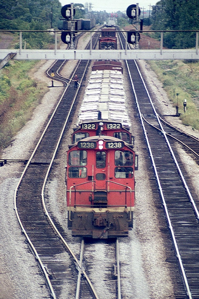Hard to believe this image was taken from off the Waterdown Rd bridge in Aldershot, looking east. Today you would see a lot more track, as in yard leads; plus GO and VIA platforms and the Aldershot GO station off to the left. It has all changed. But then, this photo is from 45 years ago.
In the view, CN 1238 and 1322 are westbound, perhaps to Hamilton, with mixed freight. I miss these versatile little switchers.