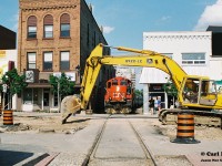 Also during 1997, King Street in Uptown Waterloo was undergoing a large-scale construction project and the CN 15:30 Job is viewed now stopped between the buildings at King Street after observing a piece of equipment blocking the right-of-way. 
The CN crew eventually got the attention of a few lingering construction workers that were luckily still there and after realizing their error, one worker quickly moved to rectify the situation. Once given the all clear, CN 4134 and 4137 would continue through Waterloo with nine-ex VIA Rail coaches for WSJR as well as their regular cars for customers in Elmira on the Waterloo Spur. 
