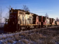 The shortest day of the year was just over a week away and you can sure tell. Only 15:00 and already it was low sun time in the western sky. The 4214, 4285, and 4232 have 40 empty hoppers and cab 79213 for a train today. They will return tomorrow night at 23:00, giving the town of Redwater a rumbling aural display of 3 GP9's climbing the hill on a cold winters night. Photo taken at a farm crossing about 3.5 miles north of Egremont.