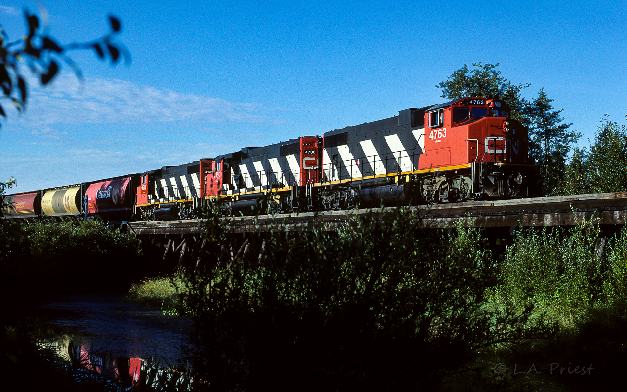Early morning photo of the Redwater river trestle from a different angle. The sulphur unit trains for years ran there and back with just open top hoppers. Starting around 88, they would also occasionally bring a short string of grain hoppers on the headend. With it being the middle of August the river is down to a trickle. Just enough for a small reflection. You can sure tell the 4782 just had its re-numbering done.