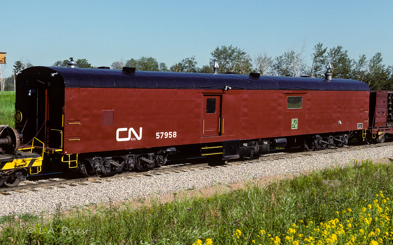 This is the promised baggage car from the auxiliary train I posted a short while back. Checking my 1989 CTG, it is reported to have been built in 1950 by NSC. Here, 38 years later, it is looking immaculate. I don't know when it was converted to Aux. Gen/Comm car 57958, it was obviously enjoying life in its new role, as it is very well cared for (nice yellow trim). Checking my other posted photo and the roof line in this picture, that seems to be the diesel with generator at this end (flapper on exhaust). The other various vents and chimneys??? All the equipment, minus a coach, is on the way back home to Calder yard. Photo taken south of Gibbons at 9:15.