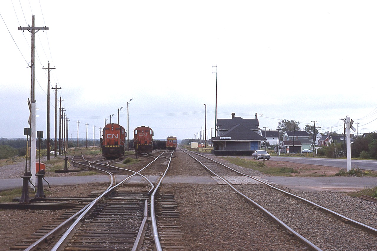 Coming onto PEI (by ferry) in 1981 I was rather surprised to see so much Island power down at the Borden yard. The station is on the left, and on the right in the yard is CN 1753 with 1751 behind, out of sight, and CN 1752 on the right. These MLW RSC-18 models would be retired by 1996 at the very latest; and according to the Trackside Guide, the 1751 ended up in Cuba!! Several buildings on the left had been razed since the last time I had photographed at this location, four years previous in 1977.
I would assume the station is long gone, as the area is totally redeveloped due to the new Confederation Bridge approach thru there. Someone mentioned to me the station was "down by the pier" but I am thinking that would be a replica. Not sure.