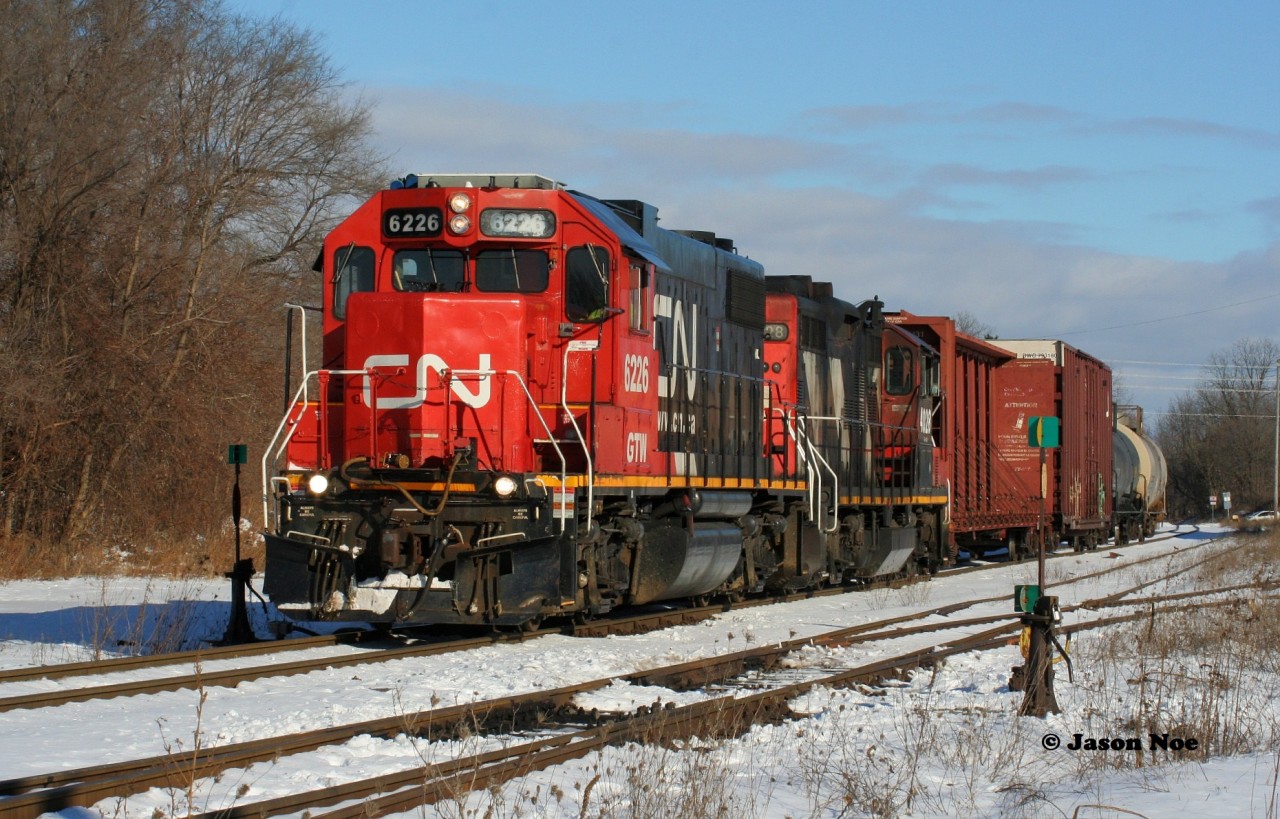 CN L540 returns westbound through Guelph from Acton on the Guelph Subdivision with GTW 6226 and 4028. The crew will lift three cars in Guelph before departing westbound towards Kitchener. December 29, 2020.