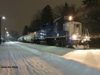 In a snow storm, CN L566 with GMTX 2264 waits near Roger Street in Waterloo, Ontario to head north to Elmira on the Waterloo Spur with six tankers. They were waiting to proceed on the shared portion of the ION Light Rail network, however a faulty switch ended L566's night early and they eventually proceeded back to Kitchener. 