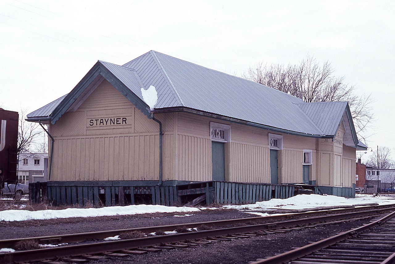 Stayner, Ontario. Former CN station.  The Ontario, Simcoe & Huron Railway came thru here back in 1860 on its way to the Georgian Bay terminus at Collingwood.  Stayner became a popular and busy stop along the way on this line from Barrie; as agriculture and lumbering were very big here.
The last scheduled train stopped in town on July 2, 1960; and powered by GO 9861 of all engines. After that, the station closed and remained so until the Stayner Co-Op purchased it and the land and used the building for storage, as you see here.
In 1985 the building was sold to the Cranberry Golf Club of nearby Collingwood. The structure was loaded up and moved by truck to the Club, where it remains today as a completely renovated pro-shop, kitchen and dining area.
It retains its 'station' appearance, but inside, well, just another building.