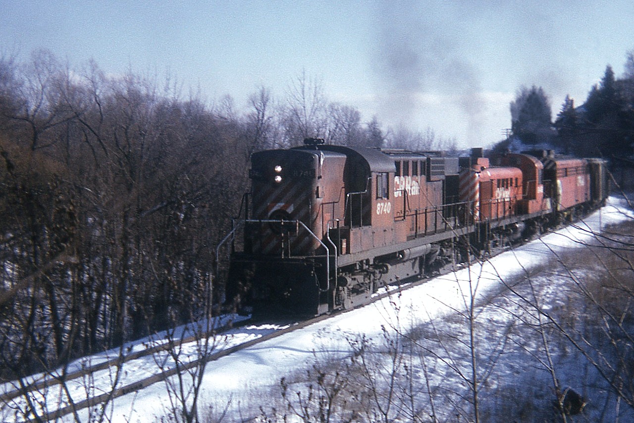 Back in the day when locomotives were nowhere near as powerful as todays, it took quite the effort to climb up the grade from Hamilton toward Guelph Jct. CP 8740 (RS-18) with CP 8446 (RS-3) and an unidentified F unit are seen working hard in this view taken near the Mill St underpass just south of Waterdown proper.