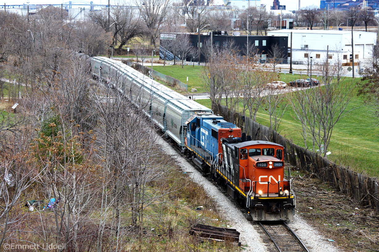 CN GMD-1u 1408 and GTW GP38-2 5849 are hard at work pulling a decently sized train from the CP interchange, with mixed freight and brand new Canpotex hoppers from National Steel Car.