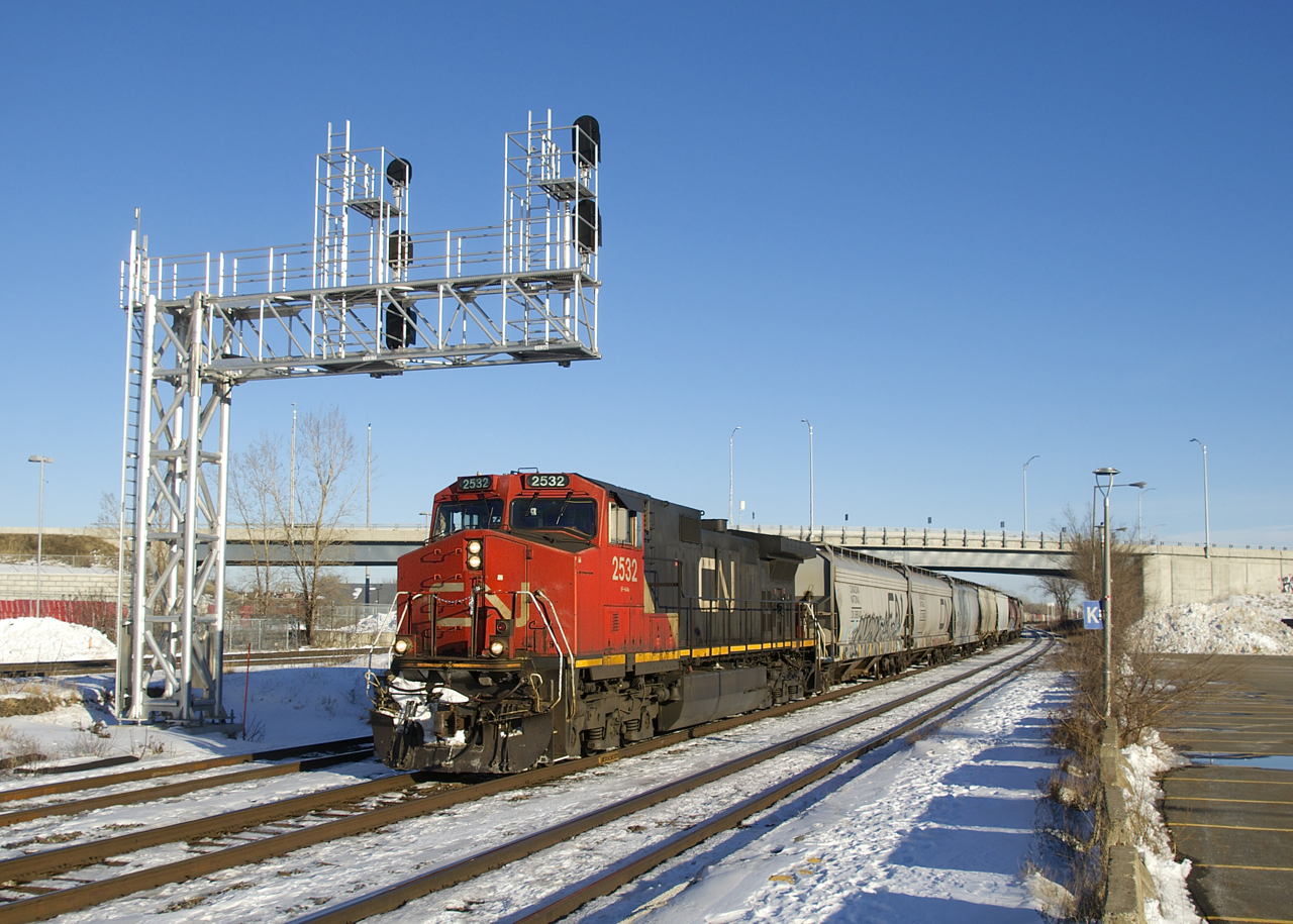 Empty grain train CN 875 is through Dorval with CN 2532 up front, CN 8883 mid-train and 187 cars.