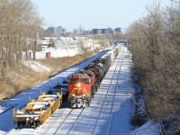 CN 527 is passing stored well cars on the freight track of CN's Montreal Sub as it approaches Taschereau Yard. Power is CN 2840, CN 2500 & CN 5600.