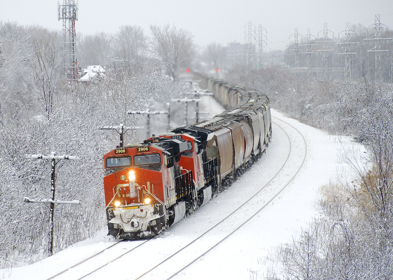 Empty potash train CN 731 has quite a bit of empty grain cars up front as it rounds a curve in Beaconsfield. Thick snow is sticking to everything the day after a snowstorm.