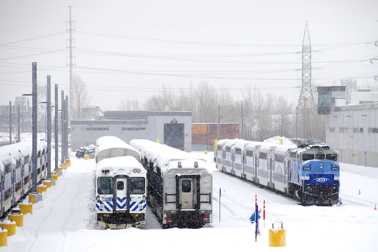 EXO equipment is seen in the Pointe-Saint-Charles Maintenance Centre as light snow falls.