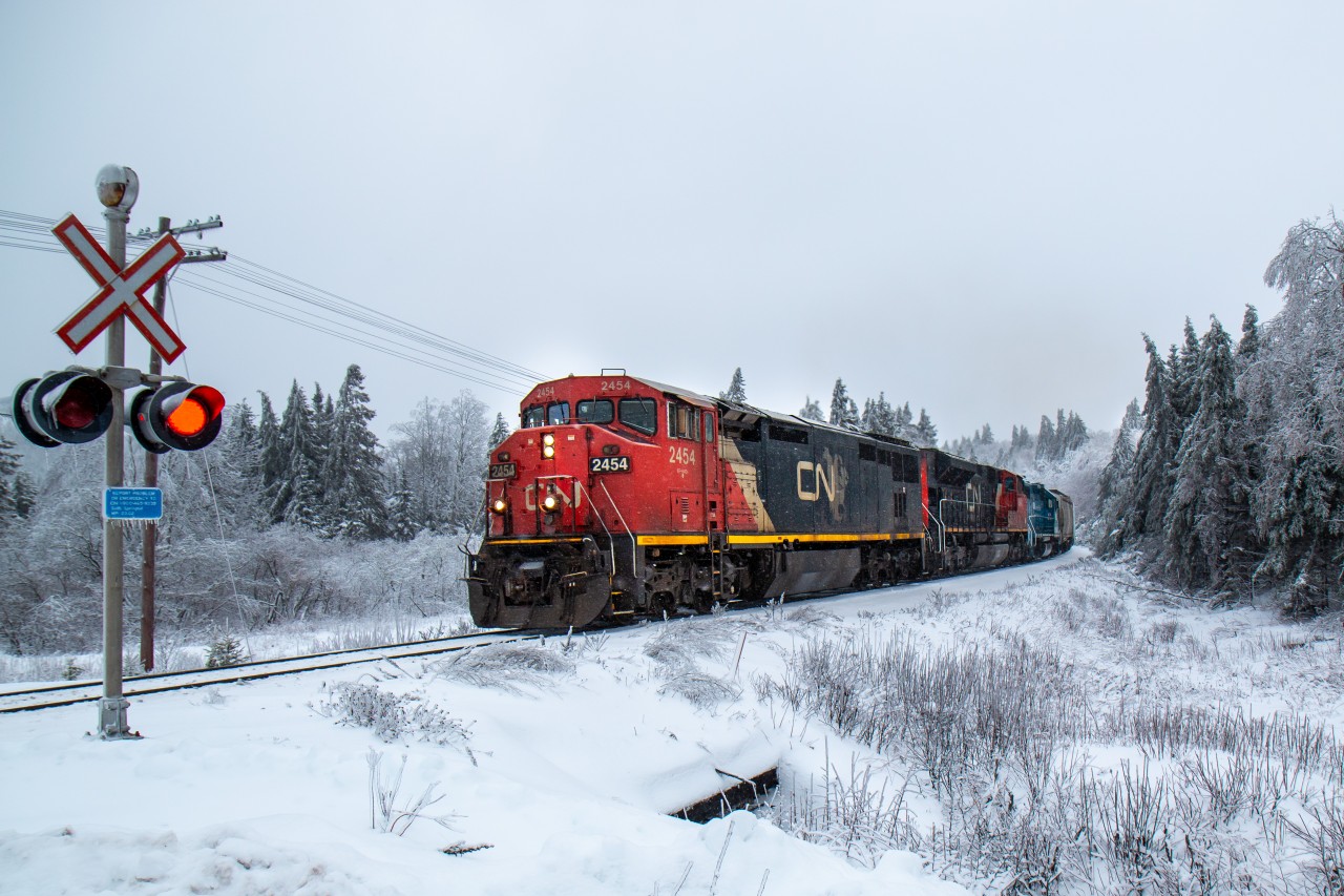 CN 2454 (GE C40-8M) with help from CN 8940 (EMD SD70M-2) and GMTX 2250 (EMD GP38-2) lead train 407 through Folly Mountain headed west towards Moncton New Brunswick’s Gordon yard