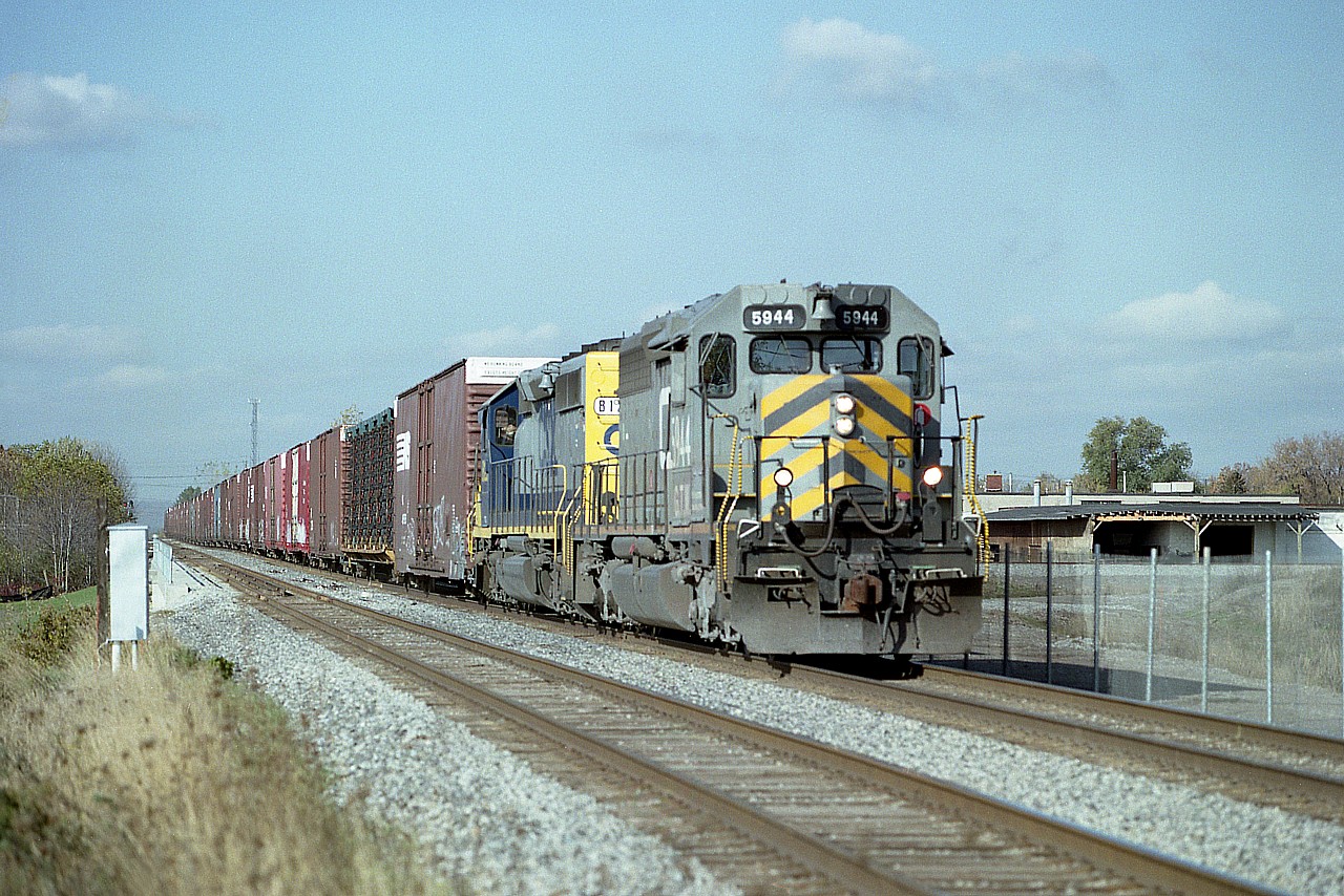 Here is another version of the NS autoparts train #328, Talbotville to Buffalo, which fans noted ran with all kinds of interesting power besides the NS or CP.  Here is GTW 5944 and CSX 8123 rolling eastward over the bridge that in 2 years would carry the tracks over the new Red Hill Valley Parkway in Hamilton, which was opened in 2007.
The GTW is on long term lease to CN, former CN 5150 SD40, upgraded by Alstom to an SD40-3, one of 19 to have been done to be slotted in CN's 5938-5956 series.