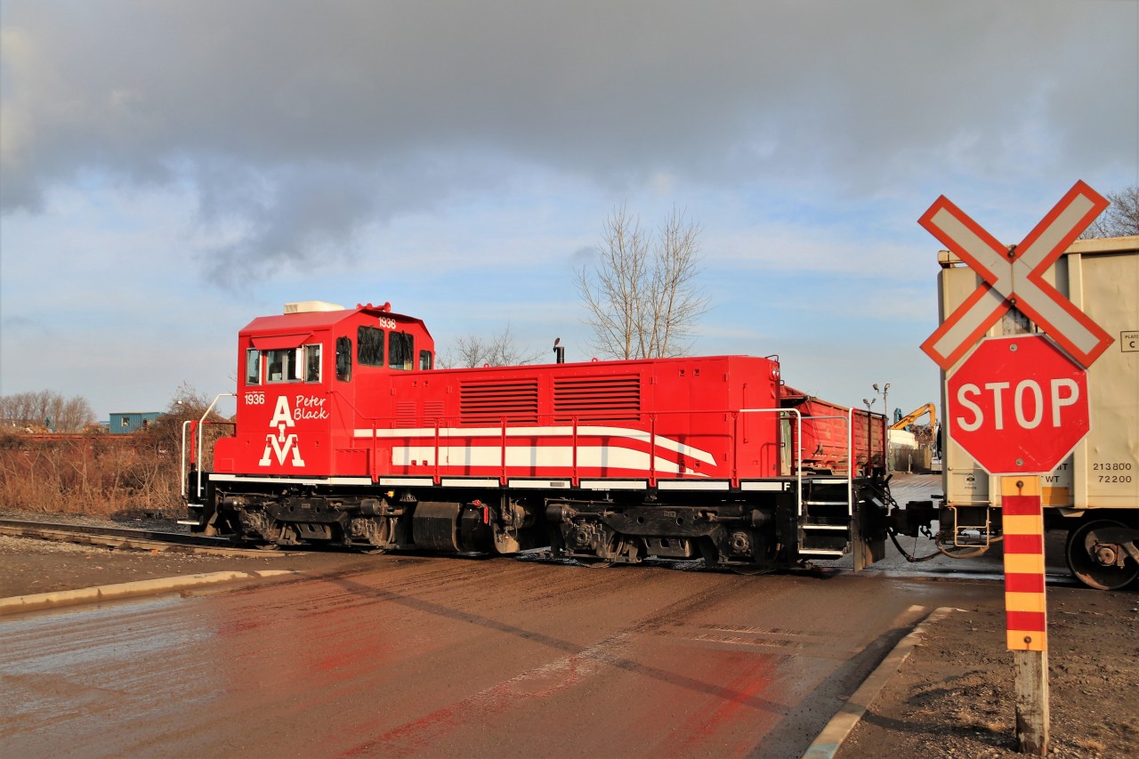 After stopping at Tim Hortons, we pulled out to head home and down the road was a string of gondolas crossing the road. Off we went and sat there for 10 minutes and the push restarted. American Iron and Metals TP90 came in to view and the sun poked out as it crossed Parkdale Avenue. AIM's history is clearly stated on it with its founding date in 1936 and its founder Peter Black.
It seemed almost like home there having worked at the former Columbian Chemicals for near 30 years.