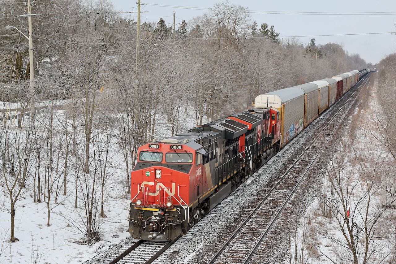 A friendly wave from the engineer as CN train 384 switches from the north to south track at Hardy in Brantford's west end. A nice layer of light snow has covered to trees here as the sun briefly peeks out before more blowing snow fills the skies once more.