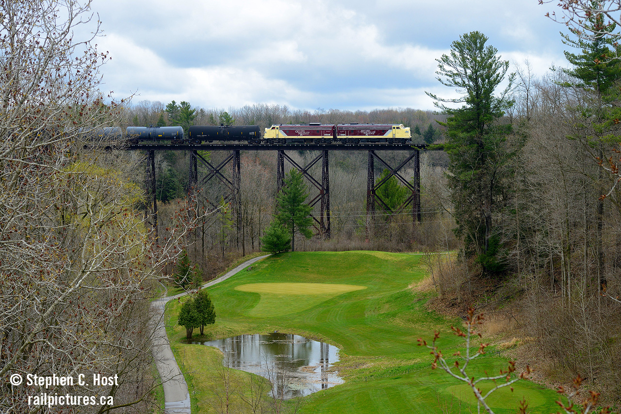 Soaring high above the Big Otter Creek, the last OSR train, and possibly the last train ever, crosses over the huge trestle in Tillsonburg. 1253' in length, not only does it cross the river valley, but it is seen here passing over the "Bridges at Tillsonburg" golf course. OSR really knew how to go out in style with these covered wagons. Well done.