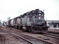CSXT GP40 6787, and a Seaboard painted Geep approach Ross Street in St. Thomas with R320 on March 16th, 1990. The blue and grey was CSX's early livery, before they added yellow ends.