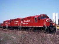 Three spiffy CP geeps have run light down from Kinnear to Fisher Yard to lift a cut of cars and drag them back up to Kinnear.  Units are 1691, 1650 and 1559.  Back then these geeps were as common as dirt and we got sick of them.  Now, it sure would be nice to see them again!  Lots of cars in Fisher Yard on this day; today there may still be a few ballast cars stored in the yard, otherwise I don't think it sees much use.   