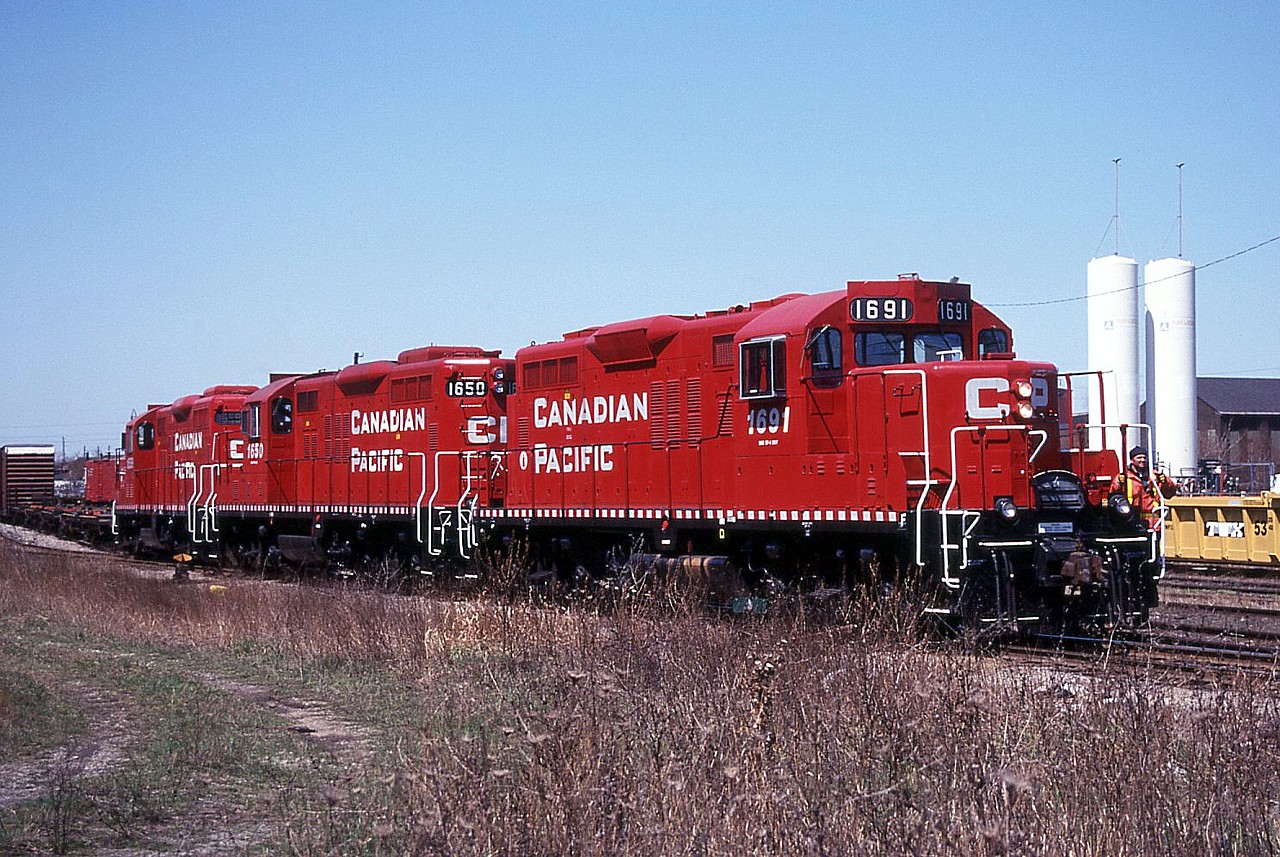 Three spiffy CP geeps have run light down from Kinnear to Fisher Yard to lift a cut of cars and drag them back up to Kinnear.  Units are 1691, 1650 and 1559.  Back then these geeps were as common as dirt and we got sick of them.  Now, it sure would be nice to see them again!  Lots of cars in Fisher Yard on this day; today there may still be a few ballast cars stored in the yard, otherwise I don't think it sees much use.