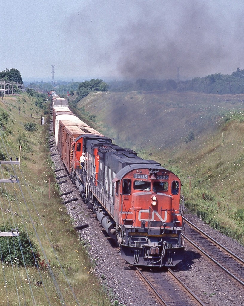Two MLW products - with a dimensional - have their work cut out approaching the Northumberland hills,


 through Newcastle, the second unit, a C-630M required a restart, hence a slow crawl up to Newtonville


 ...to hear and feel those ALCO designed engines ….simply entertaining....


 CN 2305  [ MLW M-636, 1970 ]  &  CN 2015  [ MLW C-630M, 1968 ] eastbound at the Lakeshore road horsebridge 


 Kingston Subdivision mile 284, July 25 1982 Kodachrome by S. Danko


 2305 retired by 1996; 2015 sold October 1993 to CB&CNS retired 1996.


 More C N  big M's:


   MLW's finest  


  nice pose  


  on the Sydney Sub  


  sdfourty