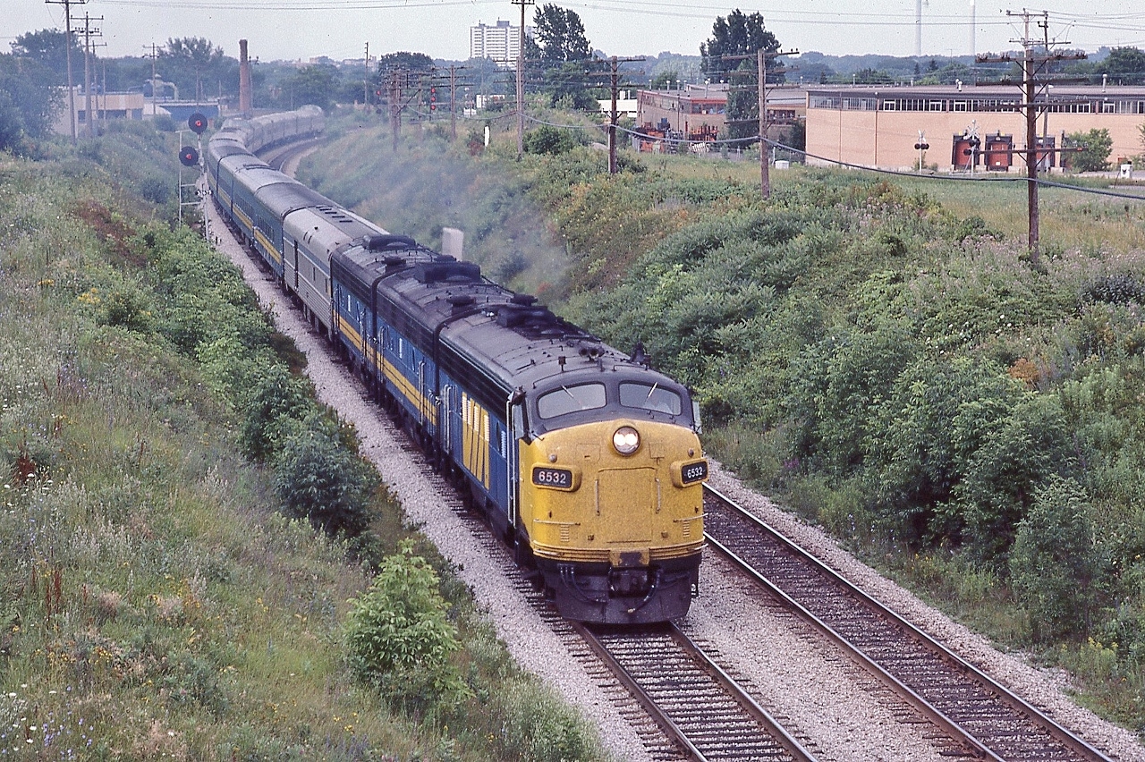 The combined VIA Rail trains #44 #54 #2


 yes! Three trains in One, and yes, Daily !


 a k a   Capital   Lakeshore   Canadian   Canadien


 FP9A #6532, a GMD 1957 product, leads the combined VIA on the approach to CN Scarborough Junction


  It is a humid, hot morning on the Birchmount overpass July 25, 1982 Kodachrome by S.Danko


 noteworthy


 those westbound signals are for the GECO branch junction mile 327 Kingston subdivision 


 upper right: note the GECO branch Milne Ave level crossing


  This is one of  VIA's experiments to reduce transcontinental train costs, no Sudbury switching for the separate Toronto and Montreal sections:  82 83 84 the Ottawa valley trains were tri weekly Budd cars, Sudbury to Ottawa, by June 1, 1985 the Sudbury switching resumed with the Toronto section trains #9 and #10 
 

  colourful  


 open auto racks  
 

  more Birchmount views  


  more three in one  
 

 sdfourty